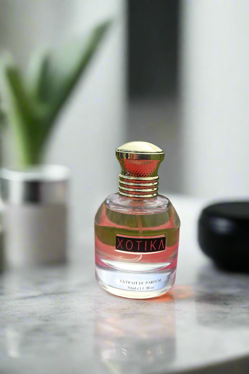 Perfume bottle with gold cap on a red and green background
